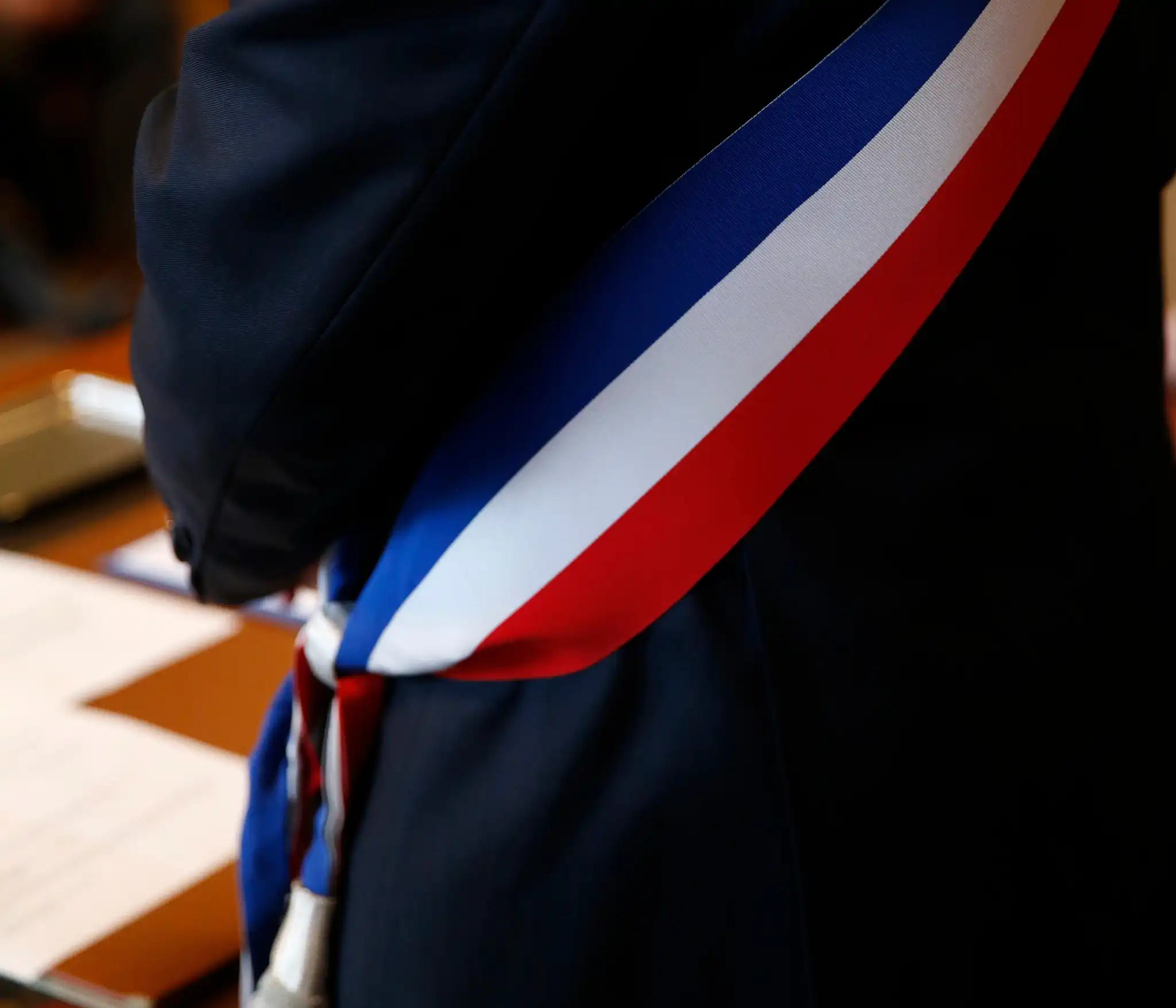 Écharpe tricolore d’élu portée sur un costume sombre